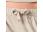 Close-up van een strik op de tailleband van een zachte grijze broek