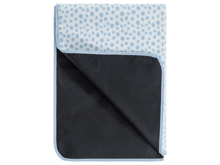 Een blauwe picknickdeken met witte stippen en een waterdichte onderkant.