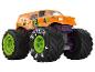 Een oranje monstertruck met grote banden en een Jester-ontwerp.