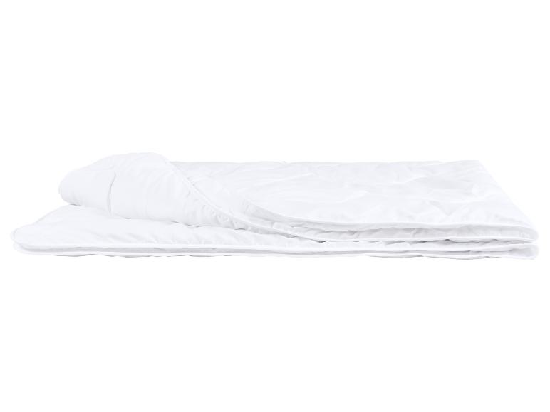Gevouwen wit dekbed met stiksels op een witte achtergrond