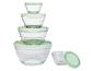 Een set glazen kommen met groene deksels.