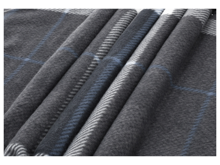 Close-up van een opgevouwen grijze geruite fleece deken