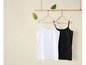 Een wit en een zwart tanktop hangen aan houten hangers