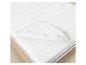 Witte matrasbeschermer met elastische banden op een houten bed.
