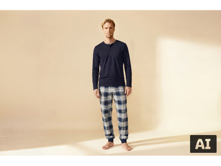 Man in marineblauwe pyjama en geruite broek, staand.