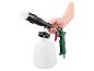 Hand houdt een groen-zwart reinigingspistool vast met een witte borstel en een witte fles.