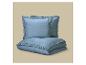 Blauw gerimpeld beddengoedset, inclusief twee kussens en een dekbed.