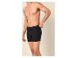 Man in zwarte boxershort, die de tailleband aanpast.
