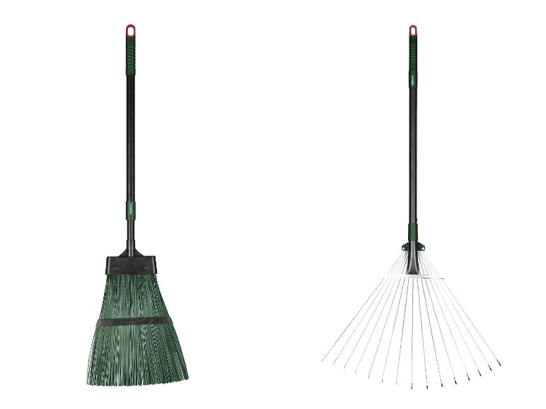 Groene tuinbezem en hark met zwarte handvatten.
