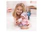 Meisje ligt op tapijt en voedt babypop met roze fles.