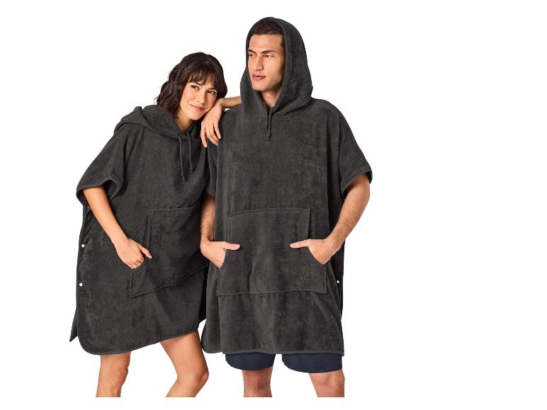 Twee personen in donkere handdoekponcho's met capuchons en zakken.
