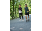 Twee hardlopers in sportkleding joggen buiten, vrouw in een jas en man in een vest.