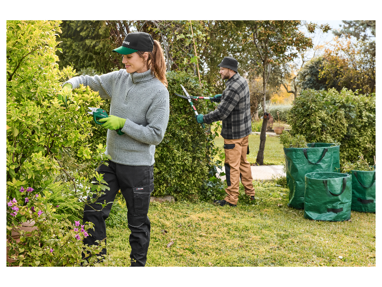 Twee personen snoeien struiken met Parkside gereedschap in een tuin.