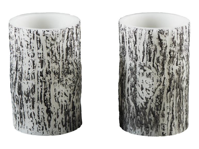 Twee witte cilindrische kaarsen met boomschors textuur