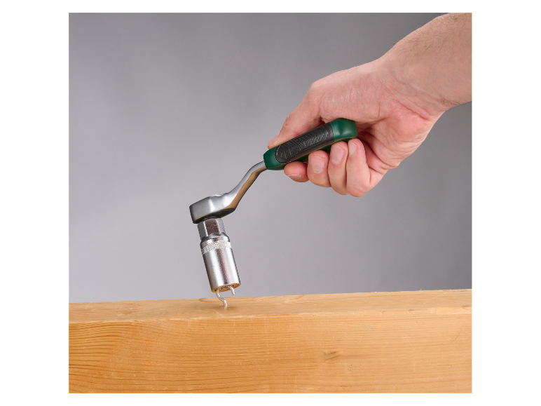 Een ratel met dop wordt in de hand gehouden en wijst naar een houten balk.