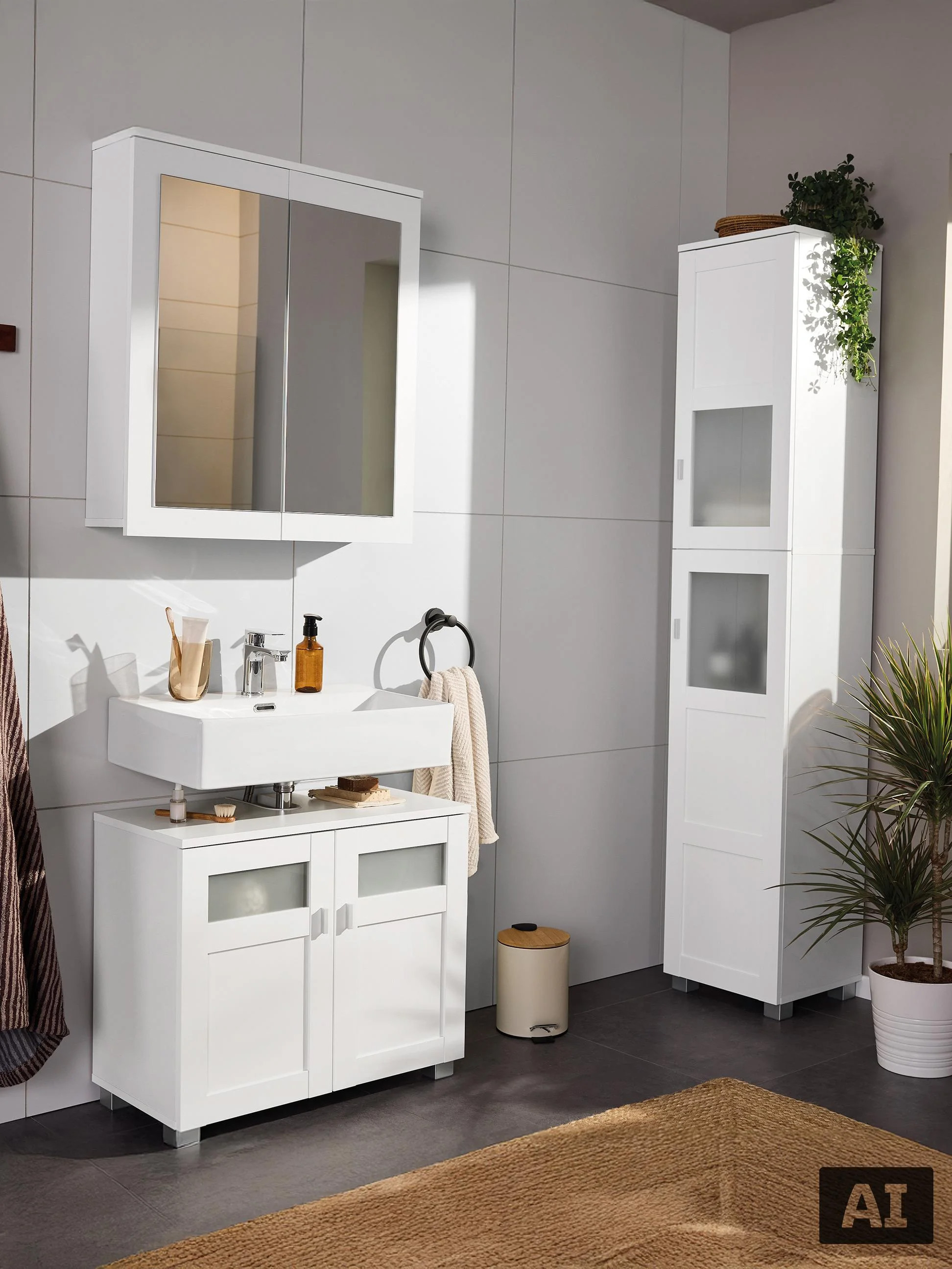 Modern wit badkamermeubel met wastafel, spiegelkast en hoge kast.