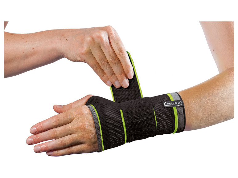 Een zwarte polsbandage van Sensiplast met groene accenten