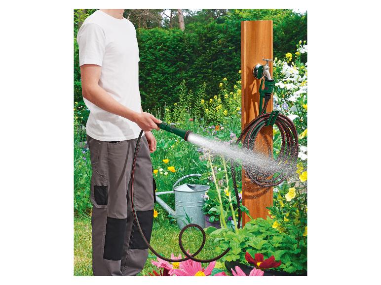 Tuin besproeien met Gardena slang en wandhouder.