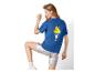 Vrouw in blauw T-shirt met ijsprint en zilveren shorts, poseert van achteren.