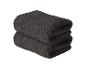 Twee opgevouwen donkerbruine handdoeken op elkaar gestapeld