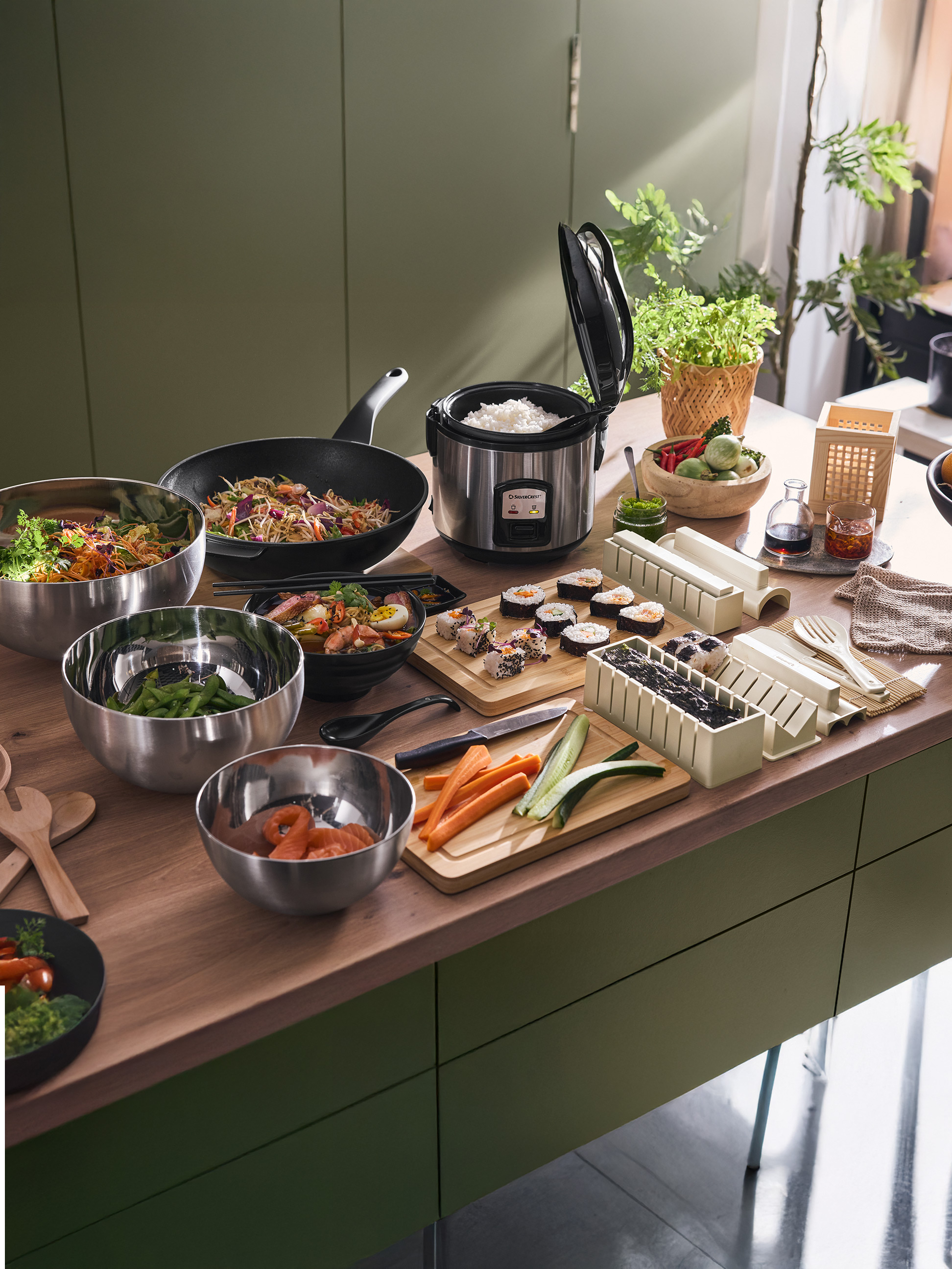 Aziatisch eten, inclusief sushi, rijst, noedels en groenten, bereid met Silvercrest-apparaten.