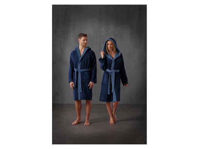 Man en vrouw poseren in badjassen met capuchon.