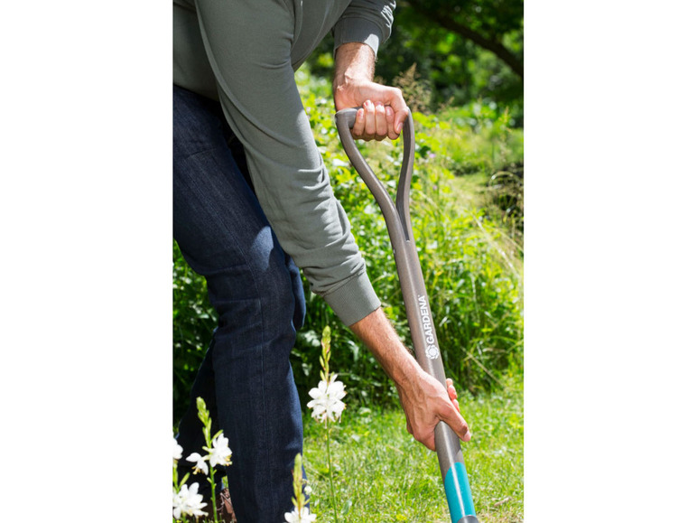 Een persoon graaft in de tuin met een Gardena schop.