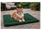 Een rode kat ligt op een groene Karlie warmtemat op het terras.
