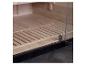 Houten sauna-interieur met glazen deur en lattenbodem.