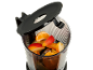 Fruitstukjes in een blender, waaronder sinaasappel, appel en mango, met open deksel.