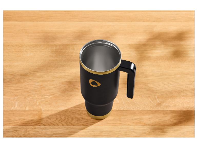 Zwarte thermobeker met gouden accenten op een houten tafel.