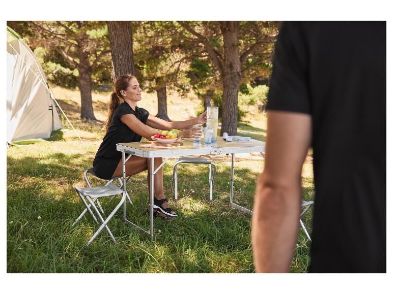 Opvouwbare tafel en stoelen buiten, een vrouw aan het eten.