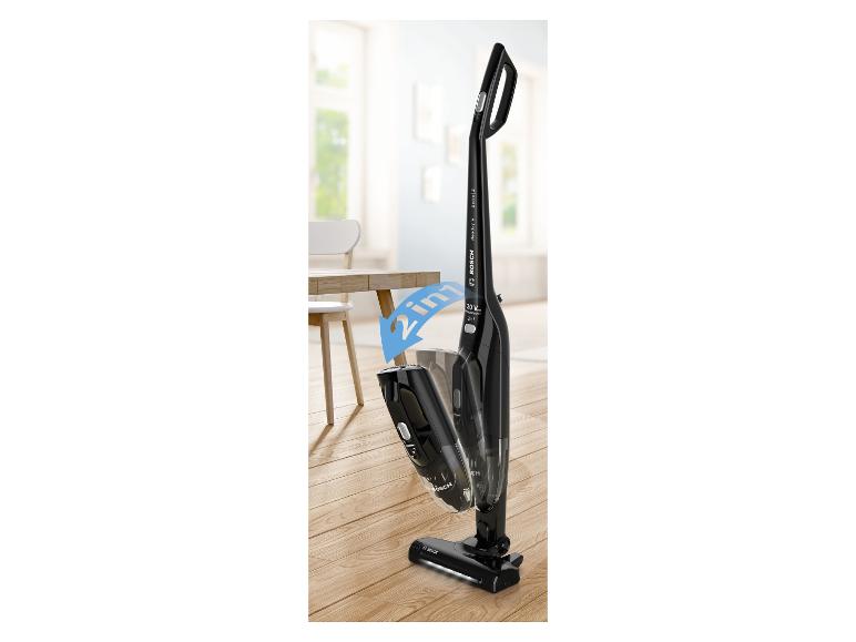 Zwarte 2-in-1 draadloze steelstofzuiger op een houten vloer in een lichte kamer.