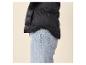 Zwarte gewatteerde jas en blauwe jeans