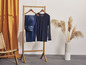 Een donkerblauw gestreept shirt en blauwe jeans hangen op een houten kledingrek.