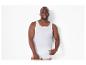 Man in wit hemd en boxershort lachend naar de camera.
