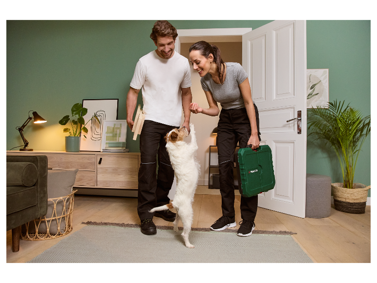 Koppel met hond thuis, vrouw houdt Parkside gereedschapskist vast.