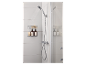 Douche met handdouche, doucherek met flessen en sponzen in een wit betegelde badkamer.