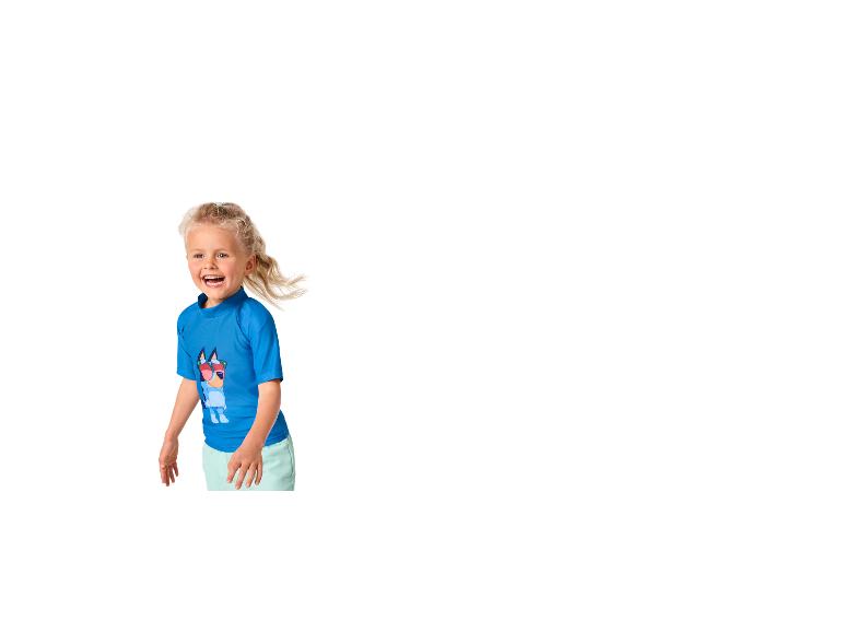 Klein meisje in blauw T-shirt met hondenprint en mintgroene korte broek