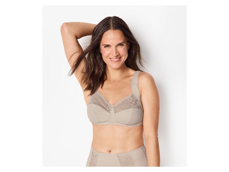 Lachende vrouw in een beige kanten beha en bijpassende slip.