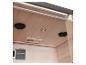 Interieur van een houten sauna met plafondverlichting, luidsprekers en een ventilatierooster.