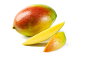 Hele mango en twee plakjes verse mango op een witte achtergrond.
