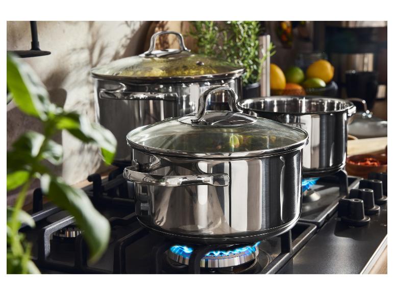 Roestvrijstalen pannen op een gasfornuis met blauwe vlammen.