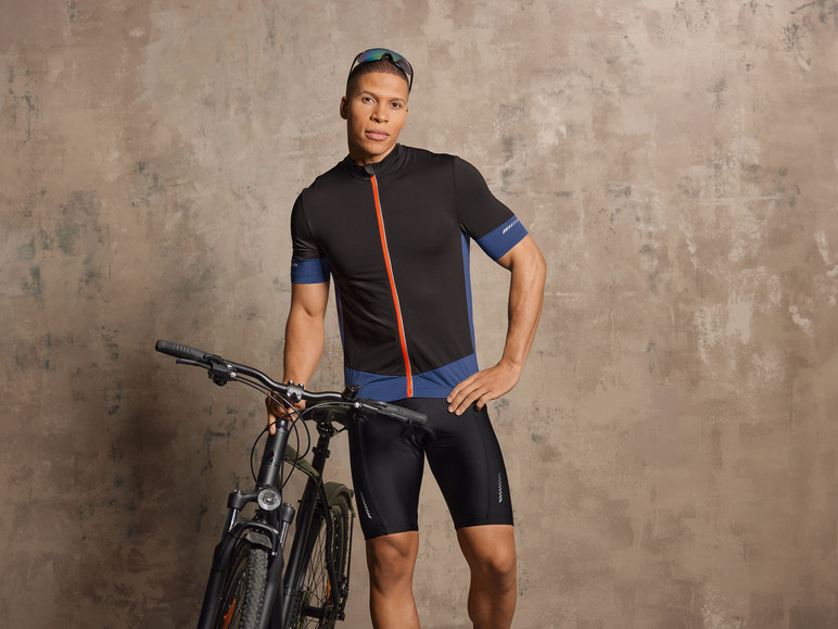 Een man in een zwarte fietsbroek en -trui met een fiets