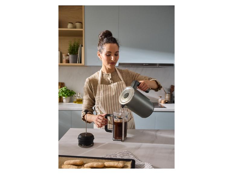 Een vrouw schenkt heet water uit een SILVERCREST® digitale waterkoker in een cafetière.