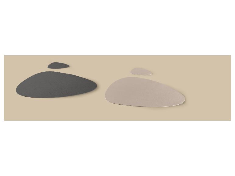 Twee sets placemats van kunstleer, één donkergrijs en één lichtbeige, op een beige achtergrond.