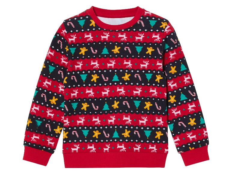 Een rood kersttrui met rendieren, gingerbread man en kerstboom