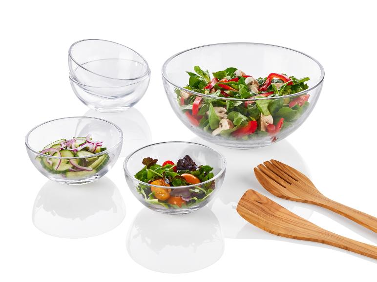 Salade in glazen kommen en houten keukengerei.