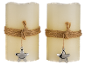 Twee beige led-kaarsen met touw en sterhanger.