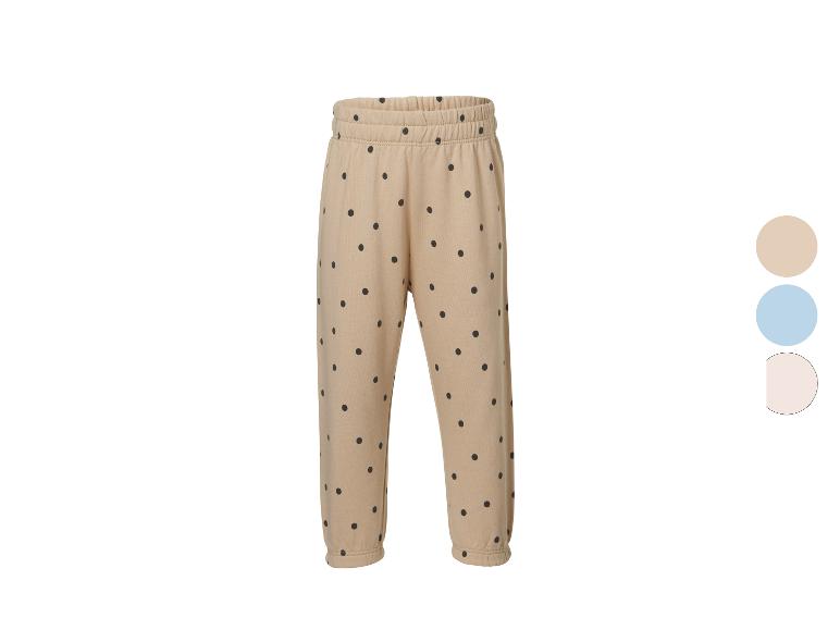 Beige joggingbroek met zwarte stippen, elastische tailleband en manchetten.